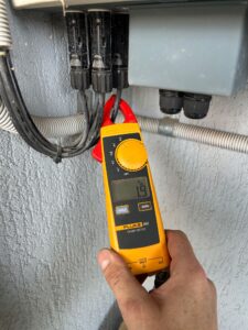 Solar electrician testing a system after reinstallation